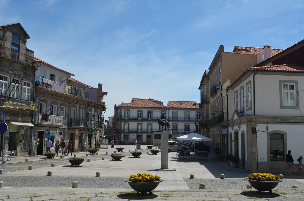 A paved square with flower planters and old houses in Viana do Castelo.