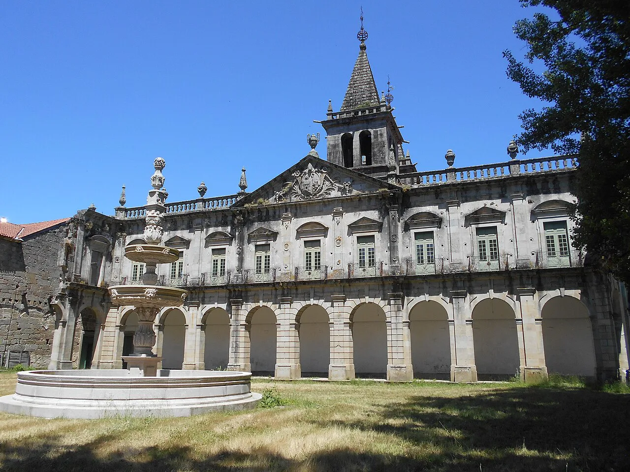 The fountain and arcaded wing of the Monastery of Pombeiro.