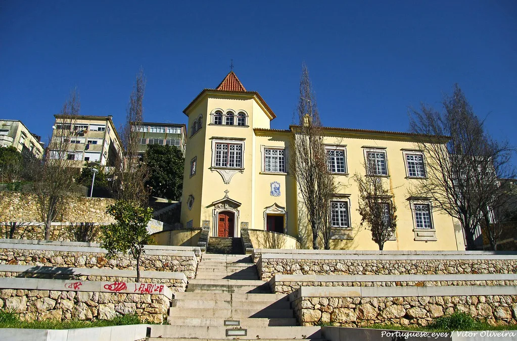 A yellow building above stone terraces in the Santa Clara area of Coimbra.