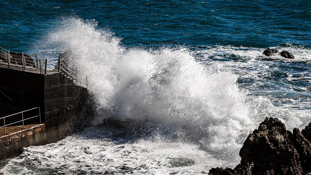 A wave breaking on the rocks at the Ponta Gorda bathing complex in São Martinho.