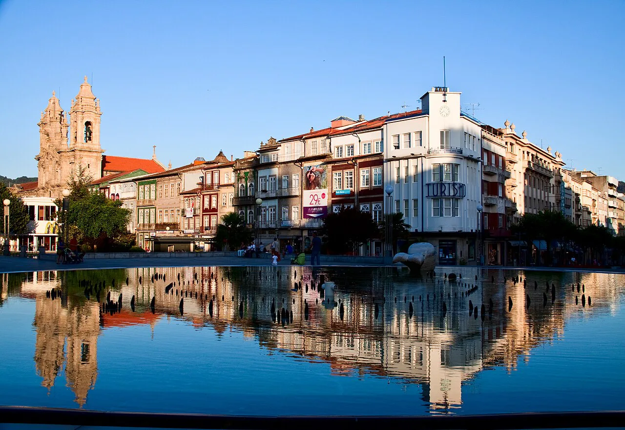 Buildings on Avenida Central in Braga reflected in a pool.