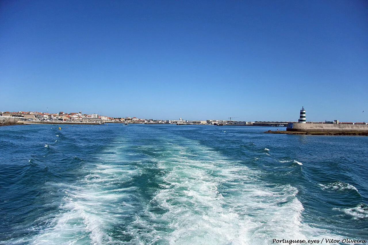 Looking back at the Peniche waterfront and lighthouse from a boat.