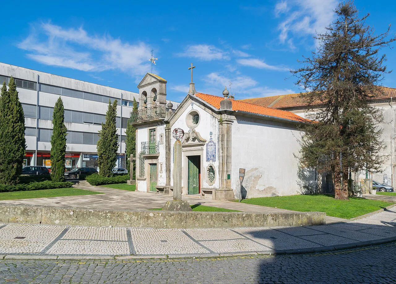 The Souls Chapel in Viana do Castelo, beside a lawn and trees.