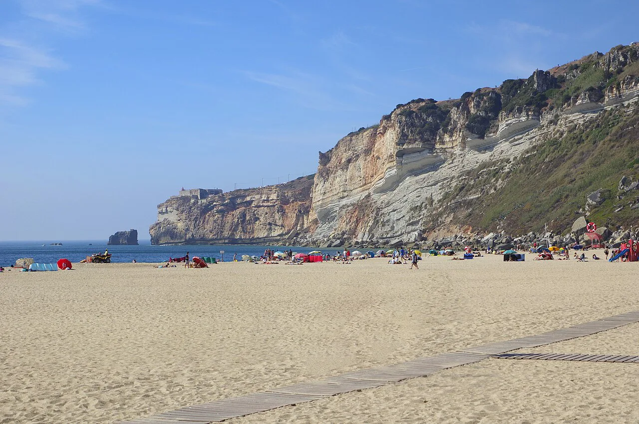 Nazaré beach with the cliffs of the headland behind it.