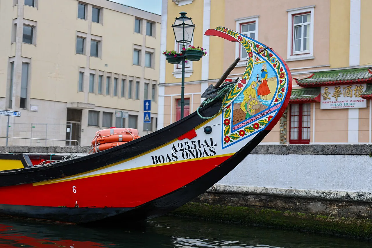 The painted prow of a moliceiro boat on a canal in Aveiro.
