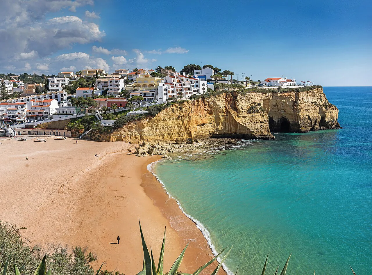 The beach at Carvoeiro, with the town on the cliffs above the sea.