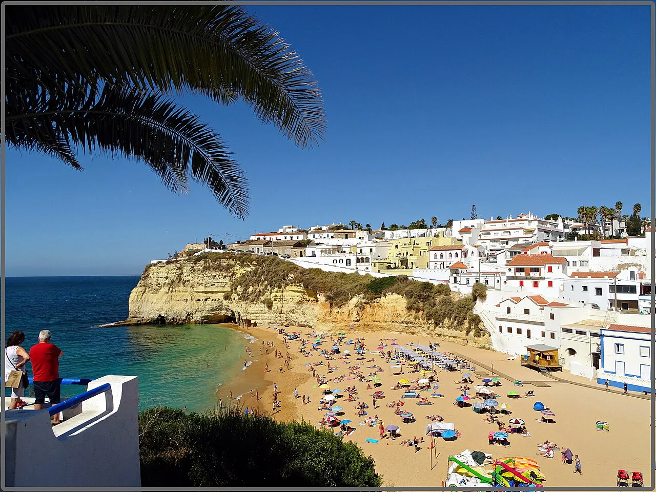 The beach at Carvoeiro, with white houses climbing the cliffs above the sand.