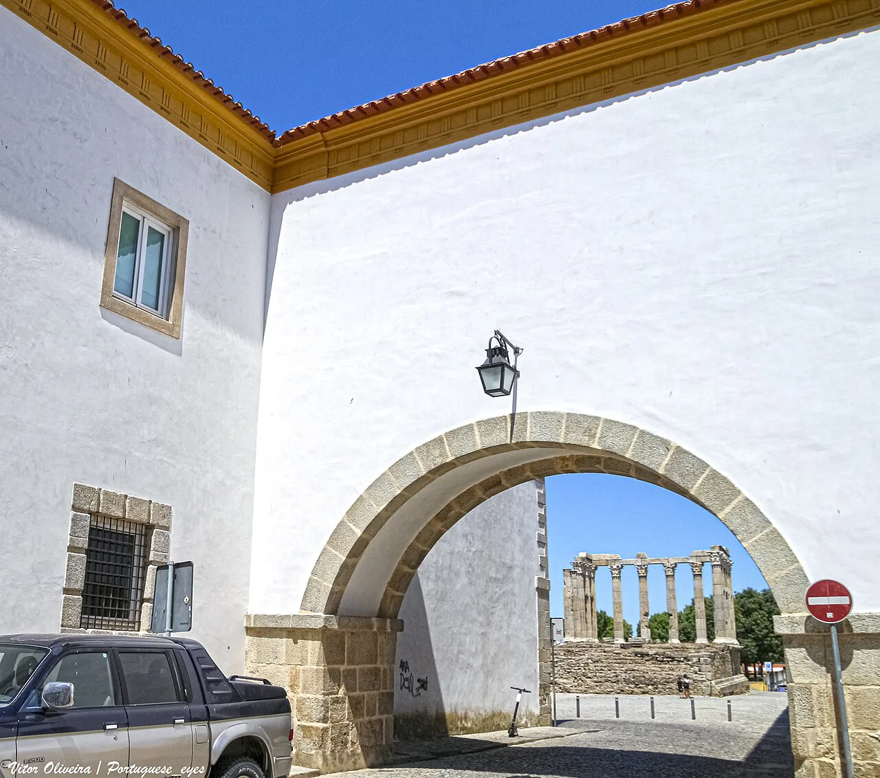 The Roman Temple in Évora seen through a whitewashed archway.