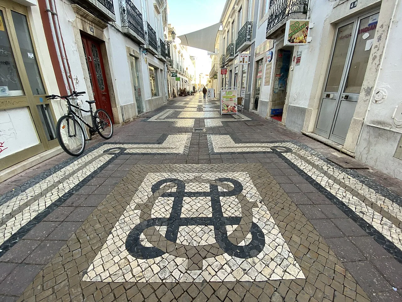 Black-and-white patterned calçada paving in a street in Faro.