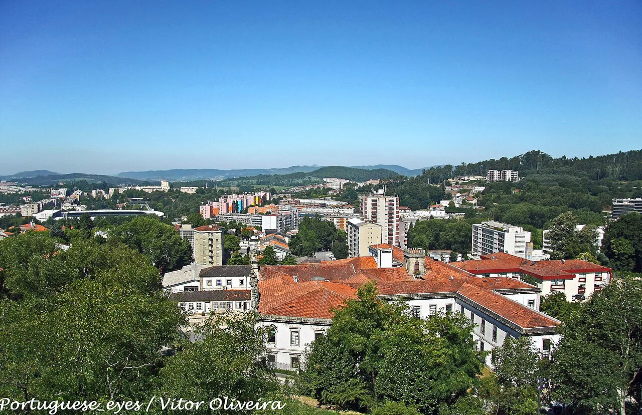 View over Guimarães, with red-roofed buildings and wooded hills.