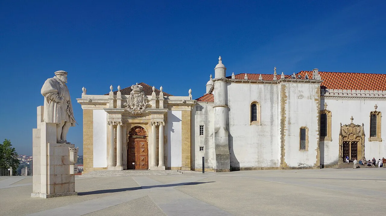 A statue and chapel facade in the courtyard of the University of Coimbra.