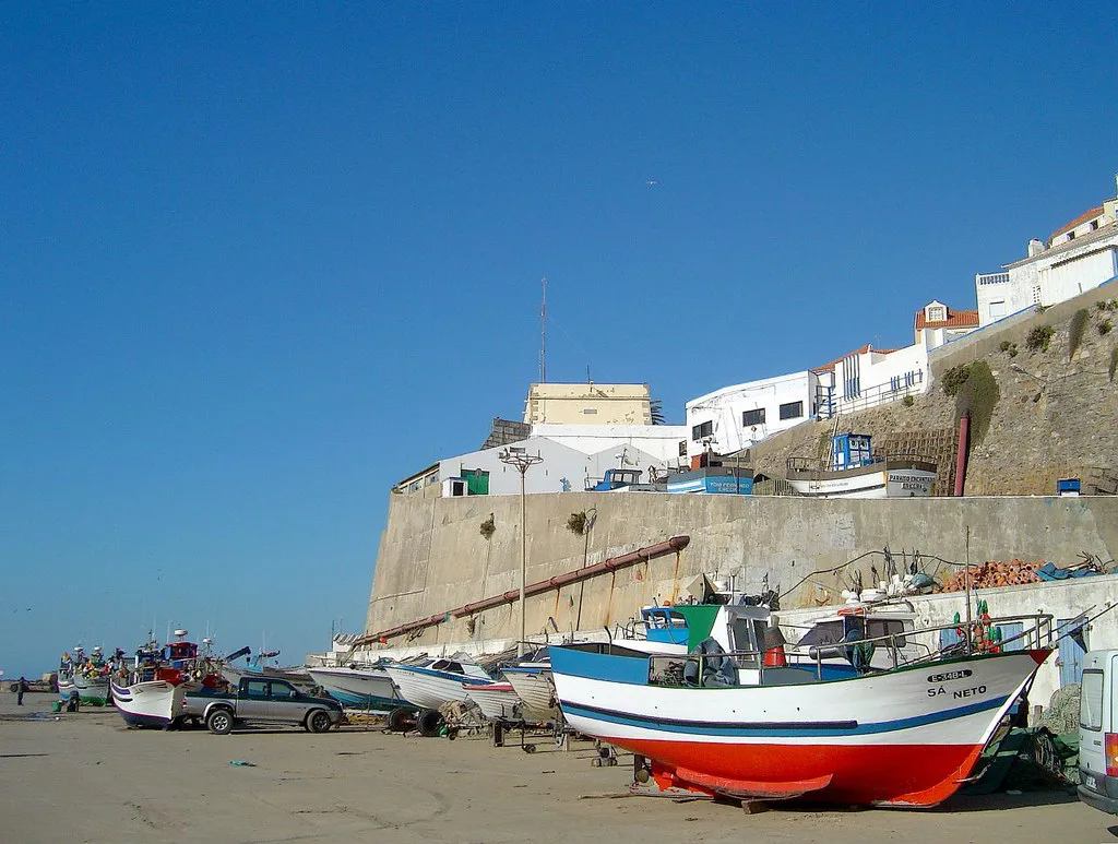 Fishing boats pulled up below the clifftop houses of Ericeira.