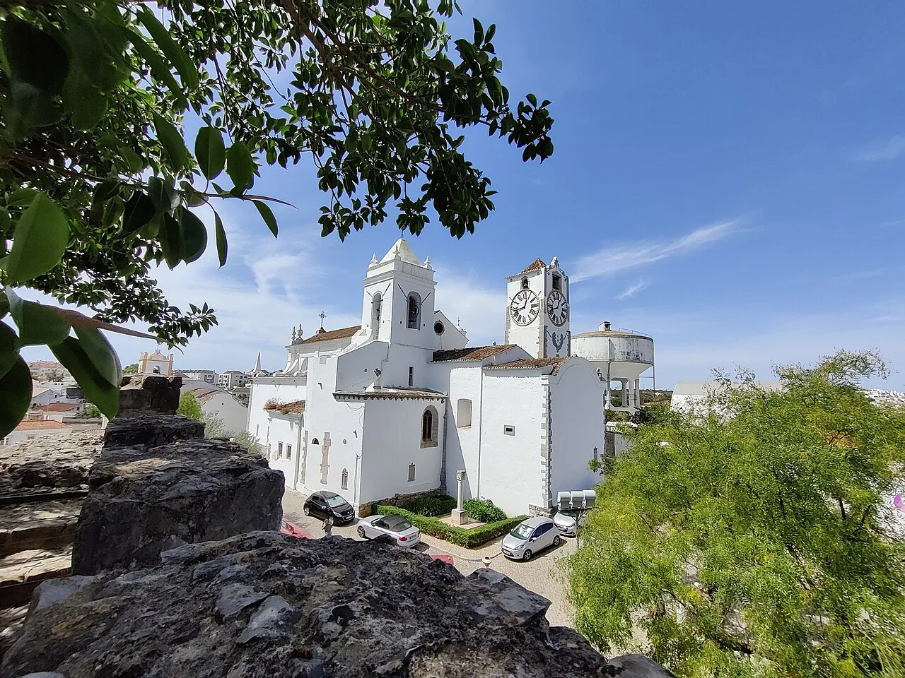 A whitewashed church seen through trees in Tavira.