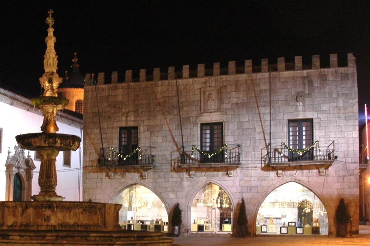 The old town hall and fountain in Viana do Castelo, lit up at night.