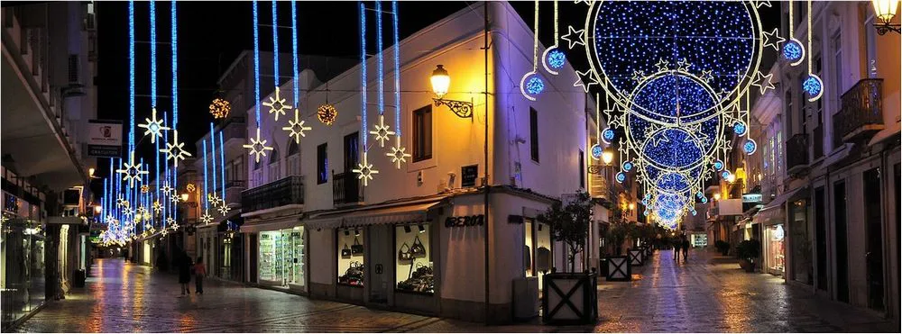 Christmas lights strung above a pedestrian street in Faro at night.